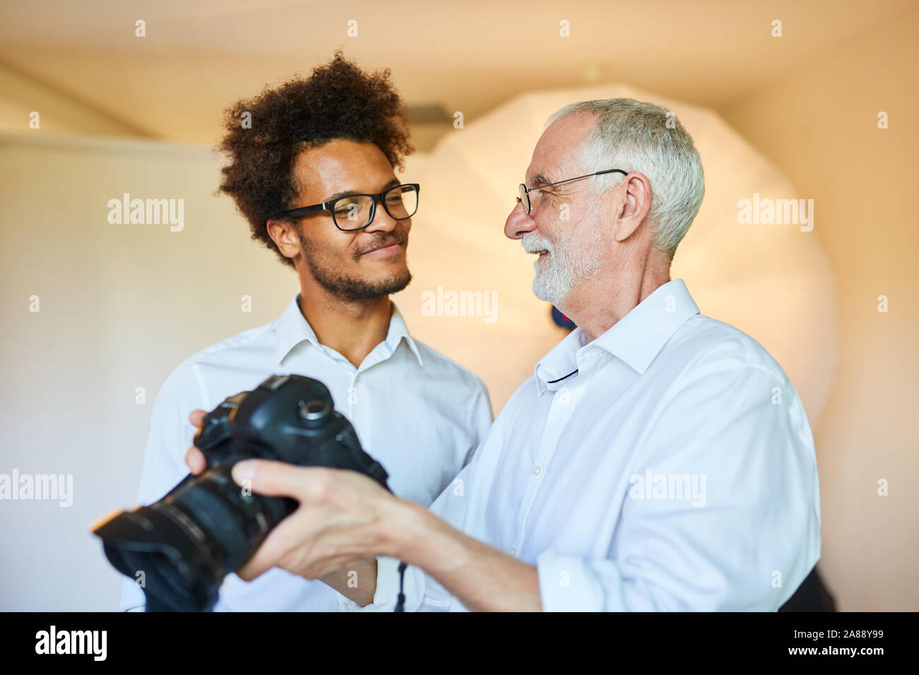 Assistant Photographe principal et photo avec appareil photo numérique dans l'école de photo Banque D'Images