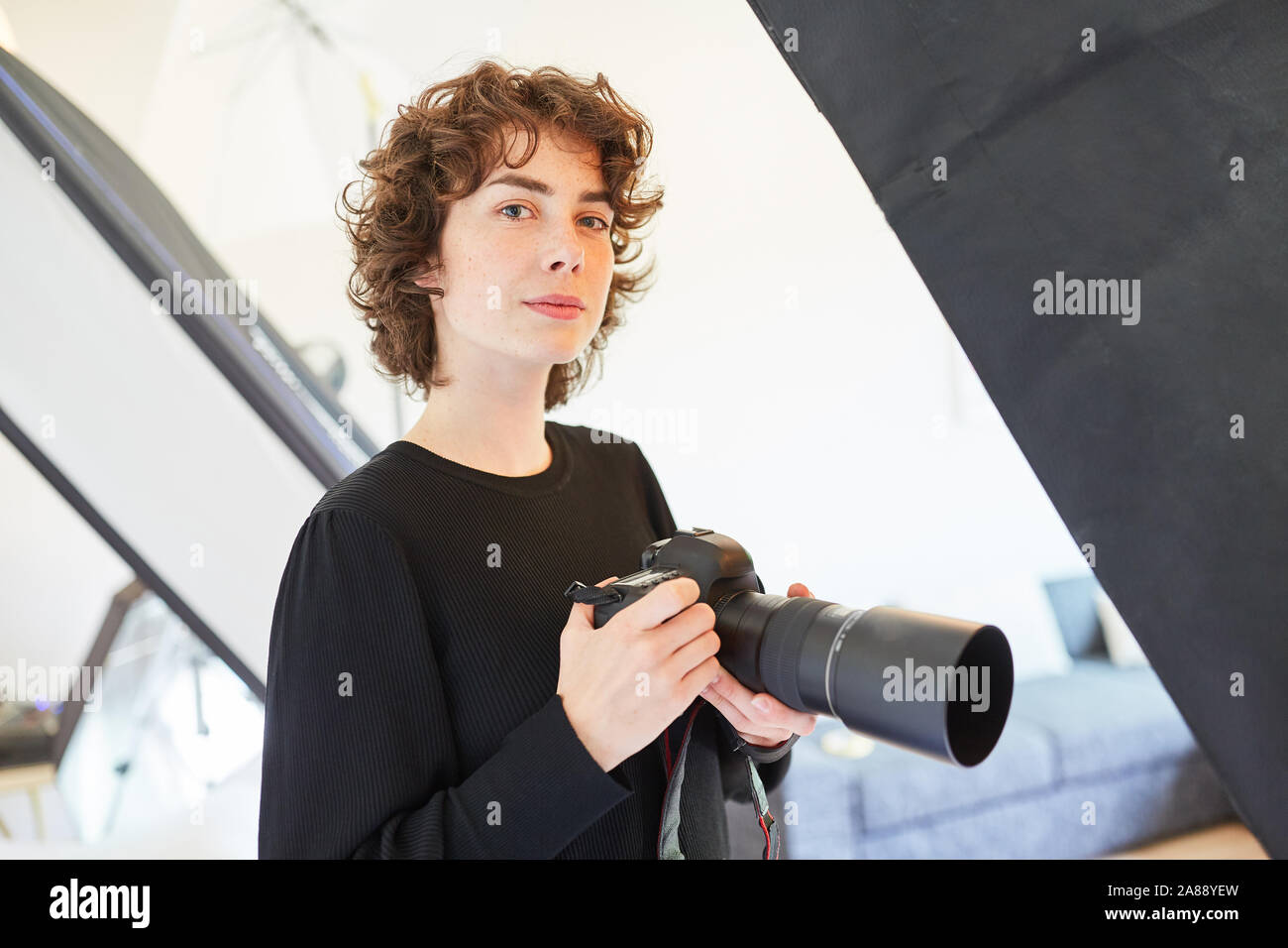 Jeune femme en tant que photographe professionnel avec caméra dans le studio photo Banque D'Images