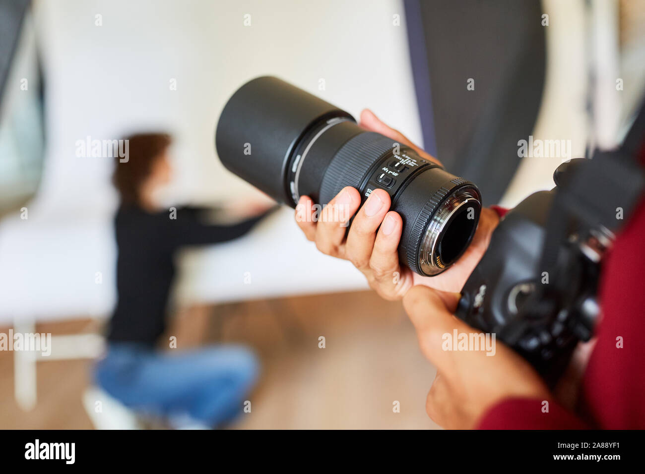 Photographe avec appareil photo reflex et objectif dans le studio photo Banque D'Images