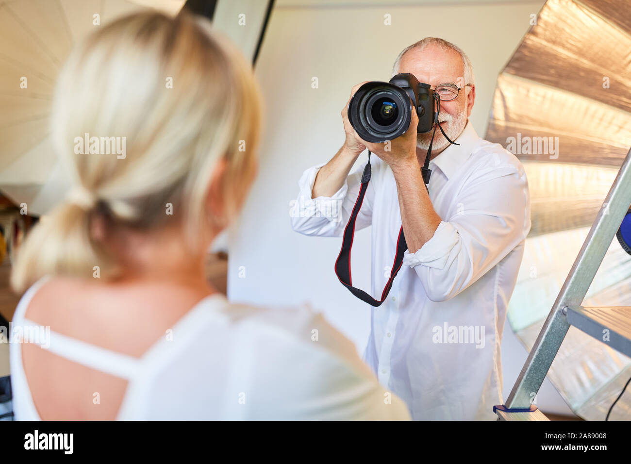 Photographe avec appareil photo numérique prend des photos portrait de femme dans le studio photo Banque D'Images