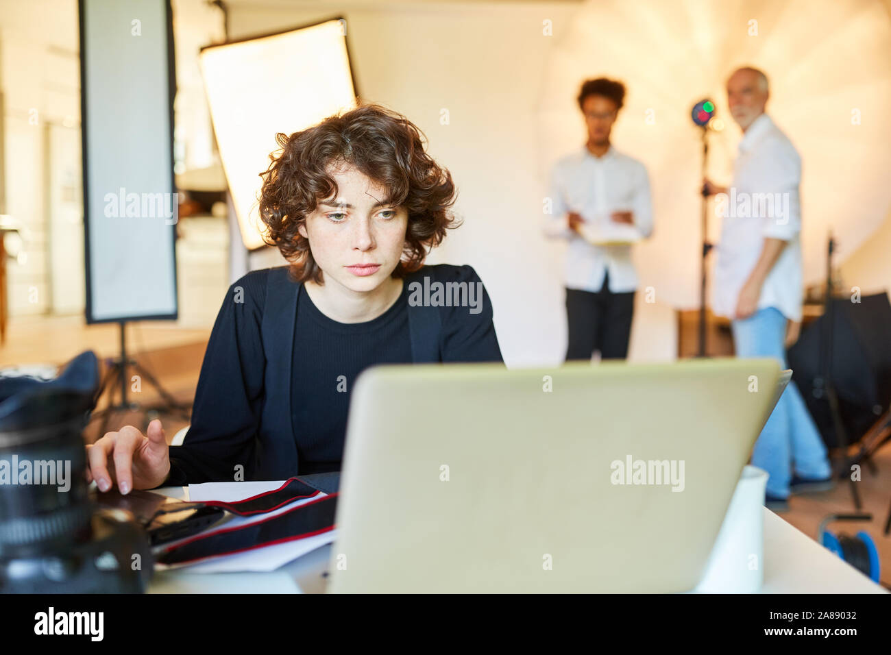 Photographe sur ordinateur portable lors de la sauvegarde dans le studio photo Banque D'Images