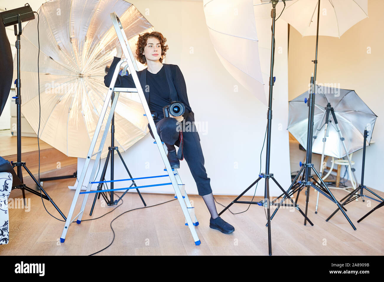 Photographe avec appareil photo dans le studio photo avec différentes lumières studio Banque D'Images