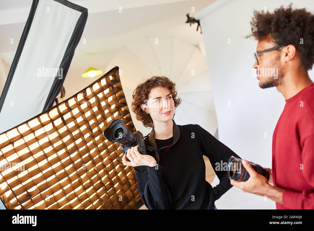 Deux photographes dans le studio, avec un appareil de discuter d'une pousse de photo Banque D'Images