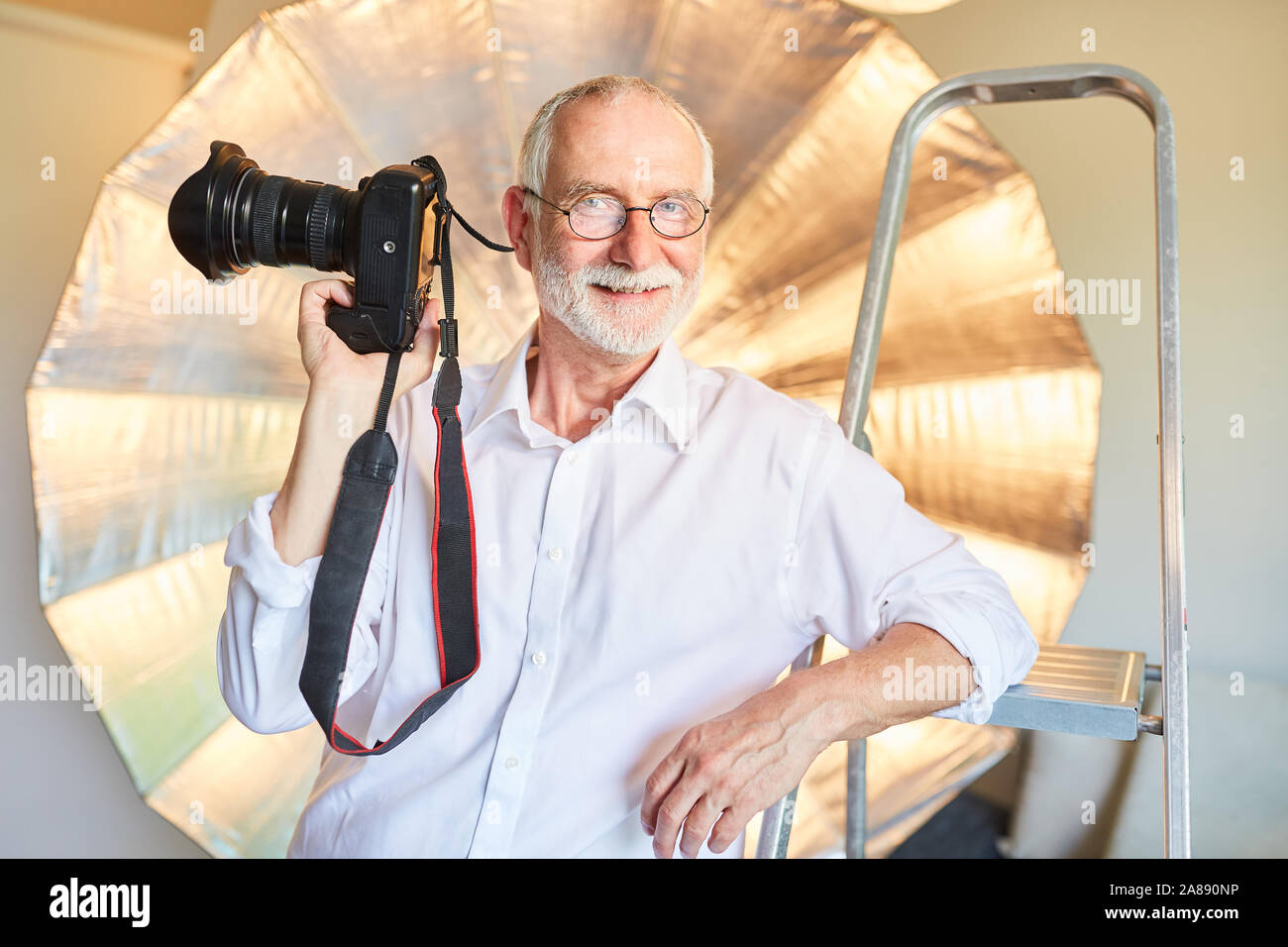 Photographe expérimenté avec son appareil photo numérique dans la photo studio Banque D'Images