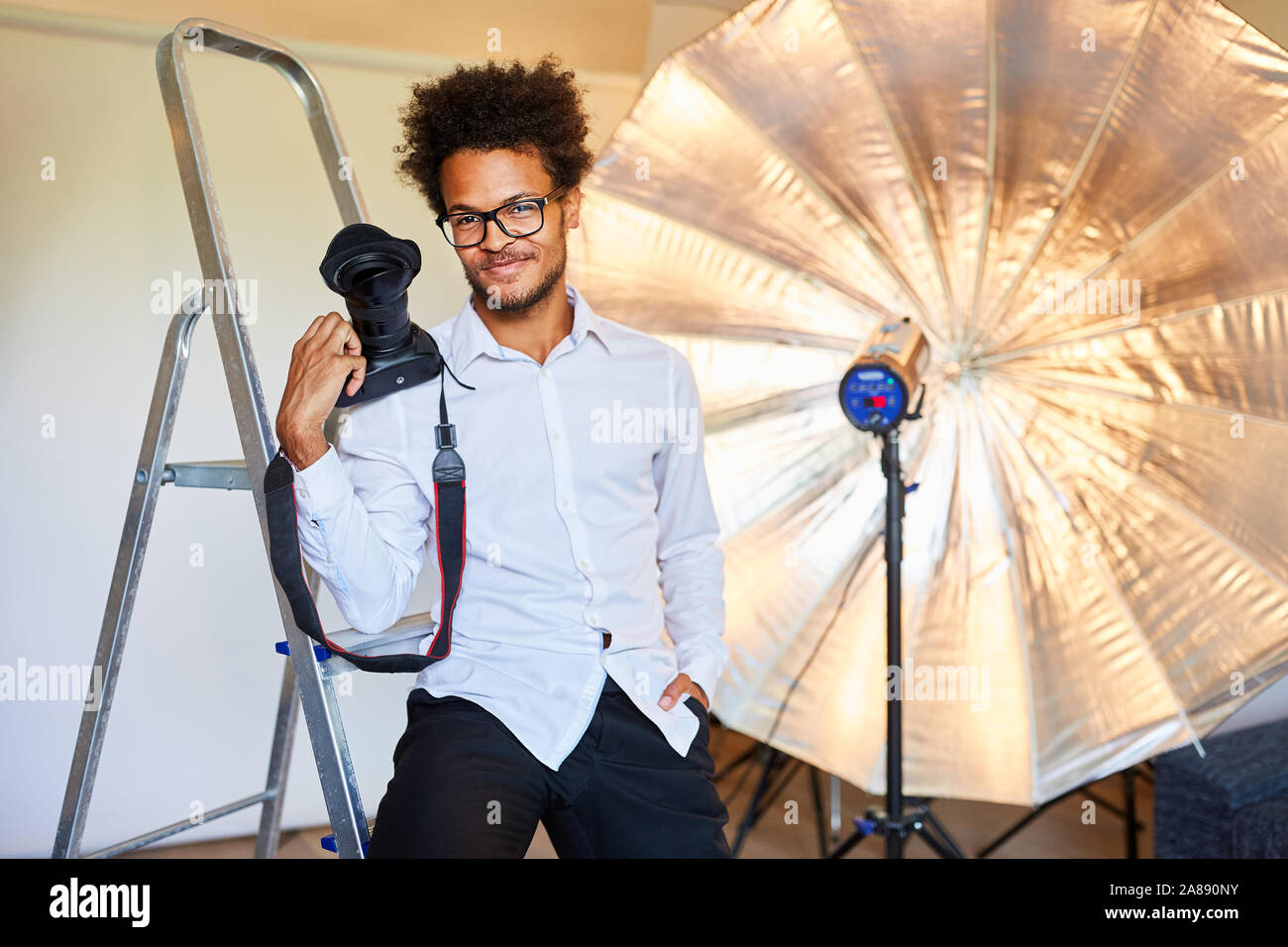 Jeune photographe avec appareil photo dans le studio photo avant la séance photo Banque D'Images
