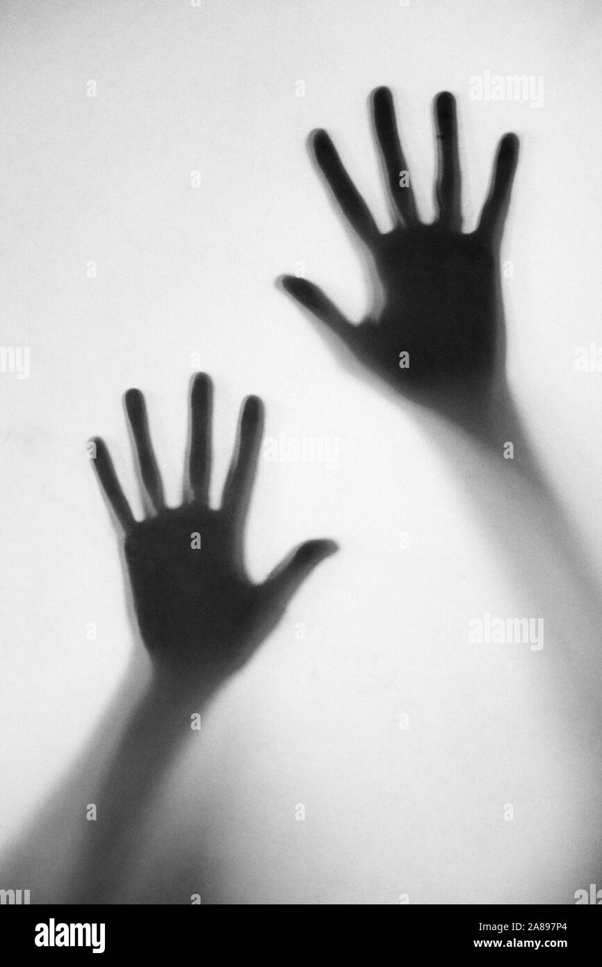 Silhouette des mains d'une femme touchant le verre dépoli Banque D'Images