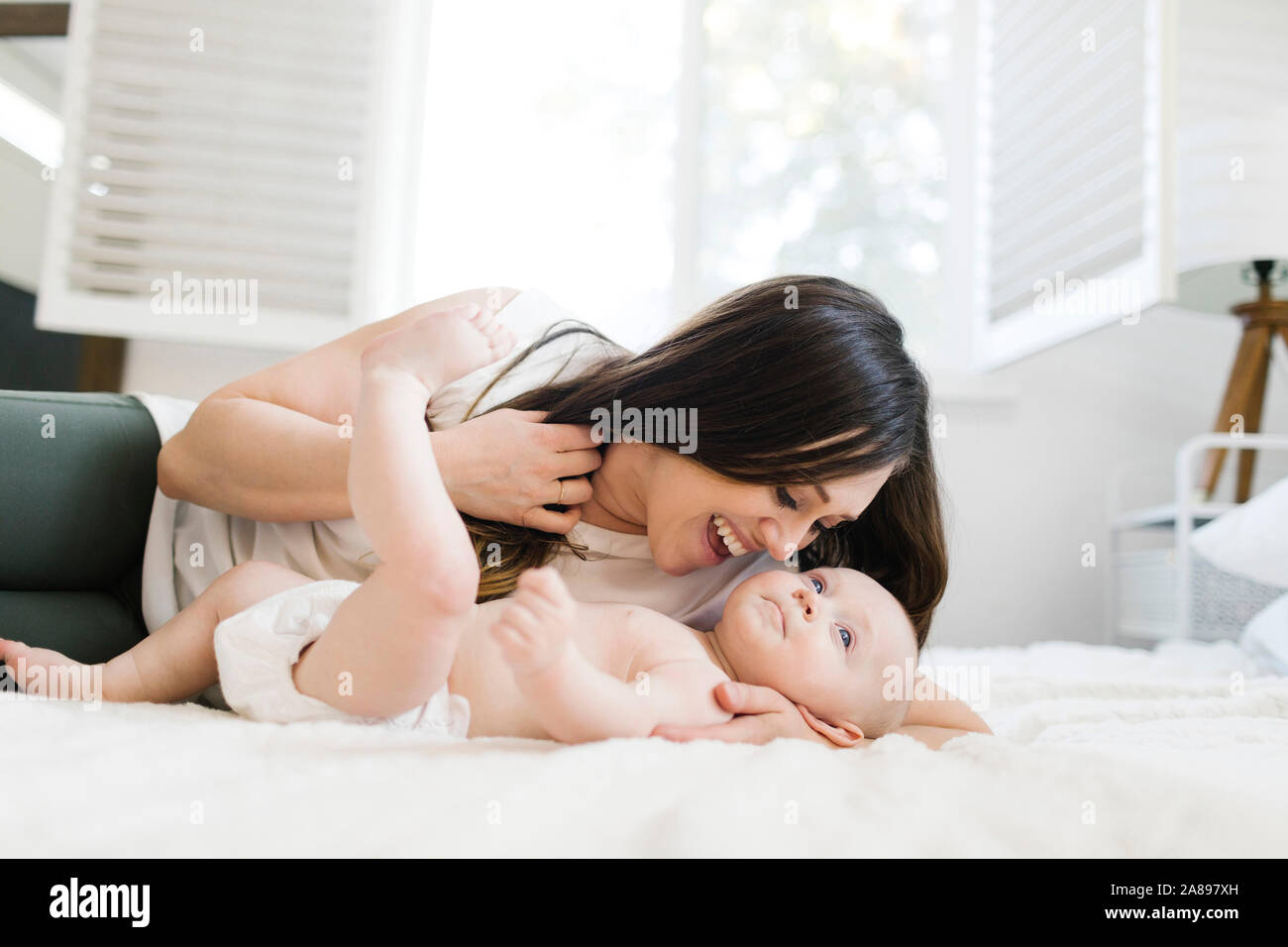 Mère souriante couchée avec son fils au lit Banque D'Images