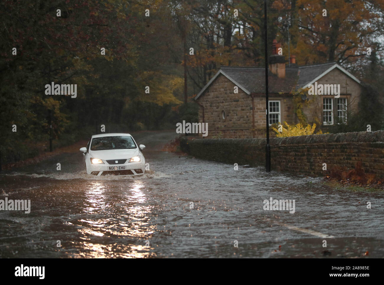 Une voiture passe à travers une route inondée à Dore, Derbyshire après des pluies torrentielles dans la région. Banque D'Images