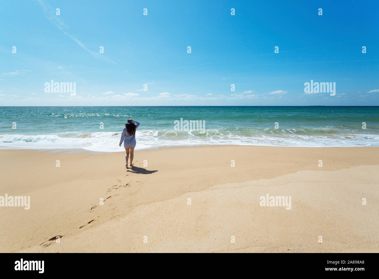 Femme marchant sur la plage à Lisbonne, Portugal Banque D'Images