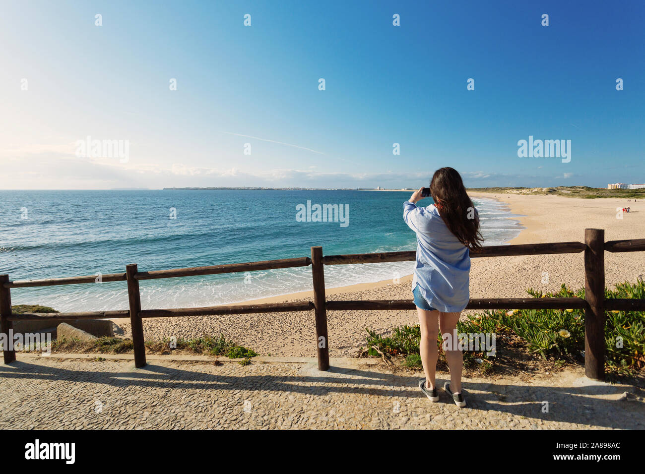 Femme photographiant la plage à Lisbonne, Portugal Banque D'Images