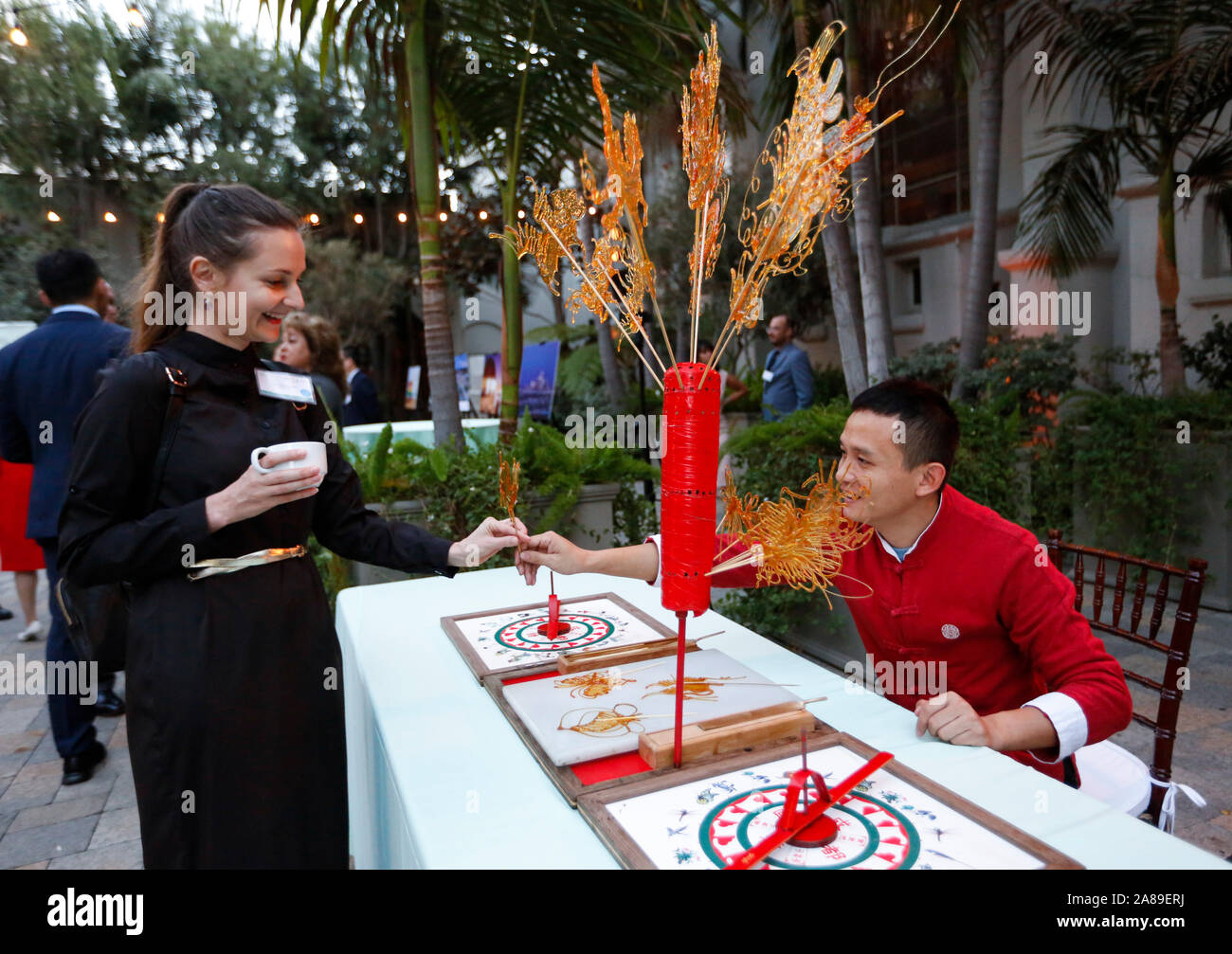 Los Angeles, USA. Nov 6, 2019. Un artiste (R) de la Chine présente une peinture de sucre à un invité pendant la 2019 Los Angeles-Chengdu la culture et l'Innovation Exchange Series à Los Angeles, États-Unis, le 6 novembre 2019. Crédit : Li Ying/Xinhua/Alamy Live News Banque D'Images