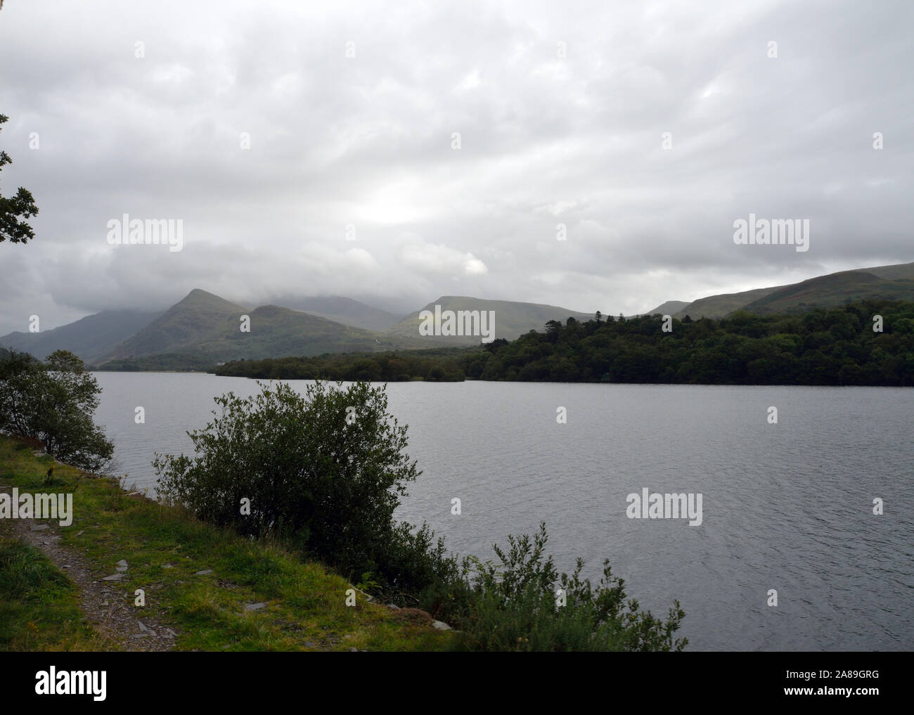 Jour nuageux, LLanberis Lake, au Pays de Galles. Vue depuis le lac Llanberis Gwynedd ; chemin de fer ; Pays de Galles ; Royaume-Uni ; Royaume-Uni ; l'Europe. Banque D'Images