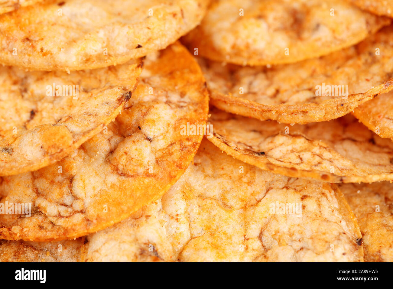 Extreme close up d'un tas de matières organiques, croustillant, riz entier, cuit au four avec des tomates et du paprika chips d'épices. Sans gluten une collation santé. Bac alimentaire Macro Banque D'Images