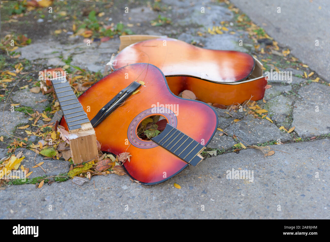 Une vieille guitare allongé sur le béton, jetés sur une rue de la ville de  New York Photo Stock - Alamy