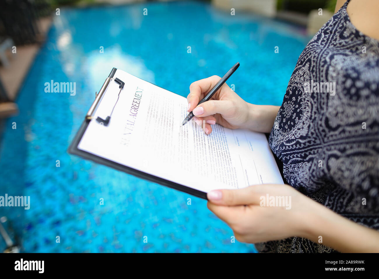 Close-up of hand of young woman signing document sur contexte o Banque D'Images