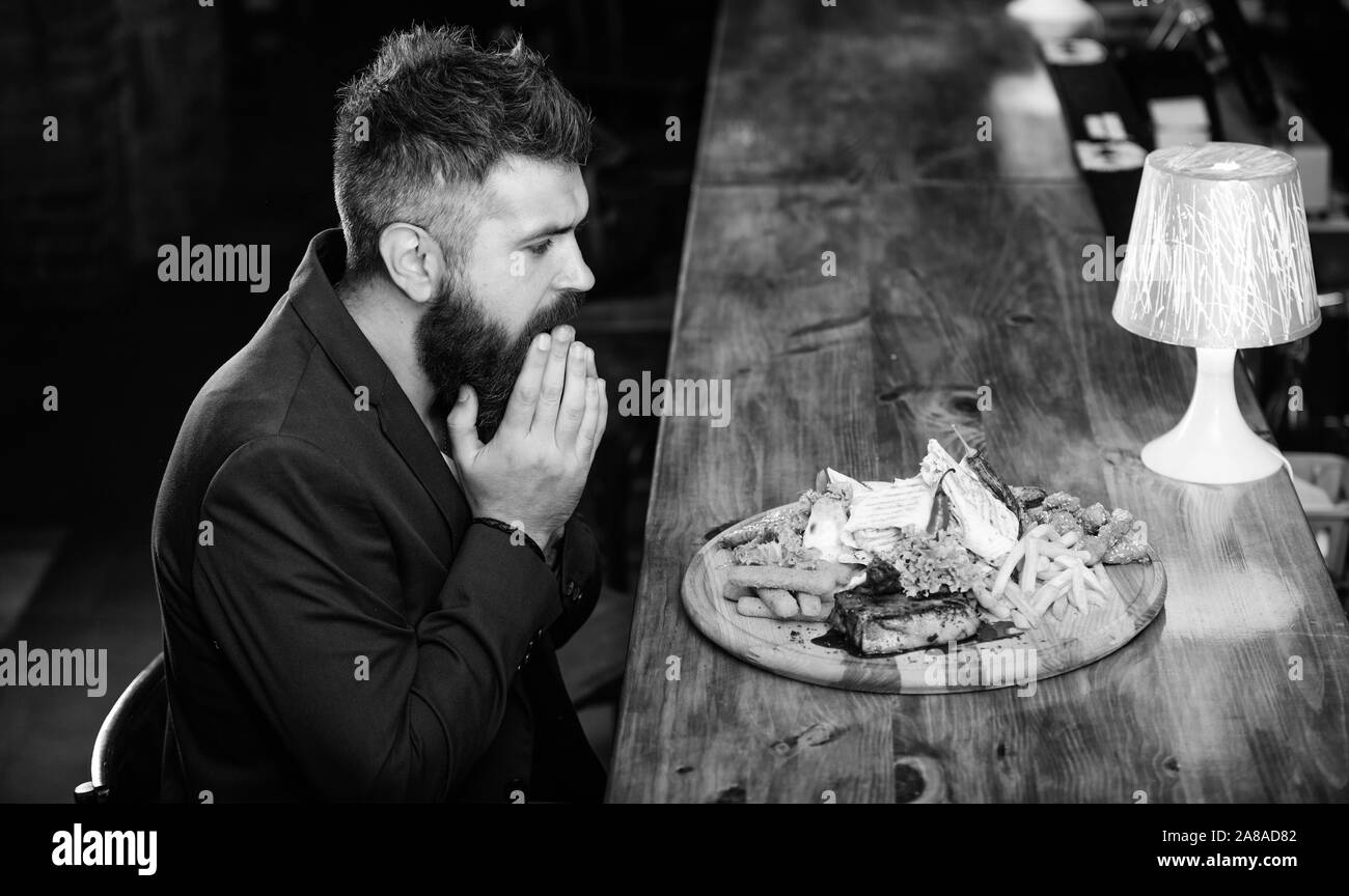 Profitez de repas. Il méritent de délicieux repas. Des calories. Vous pourrez vous détendre après une dure journée de travail. Woman costume formel s'asseoir à comptoir bar. L'homme a reçu de pommes de terre frites repas avec viande et poisson, lavash. Banque D'Images