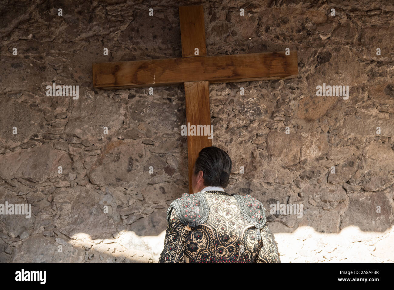 Un Matador mexicain baisers la croix à une petite chapelle avant d'entrer dans l'arène pour la féria de la Plaza de Toros à San Miguel de Allende, Mexique. Banque D'Images