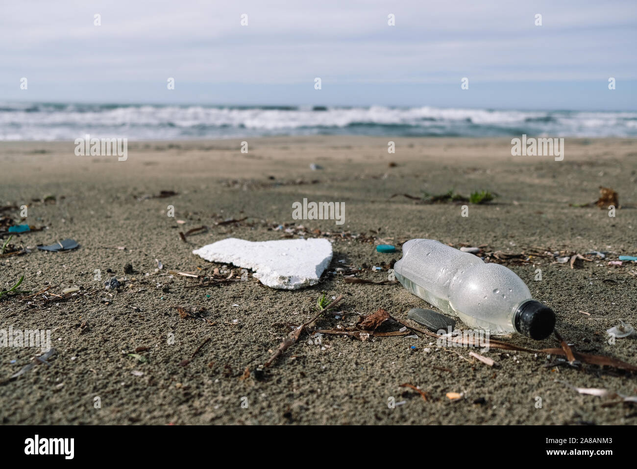 Bouteille en plastique sur la côte sauvage plus floue ondes background,planète sauvegarder Banque D'Images