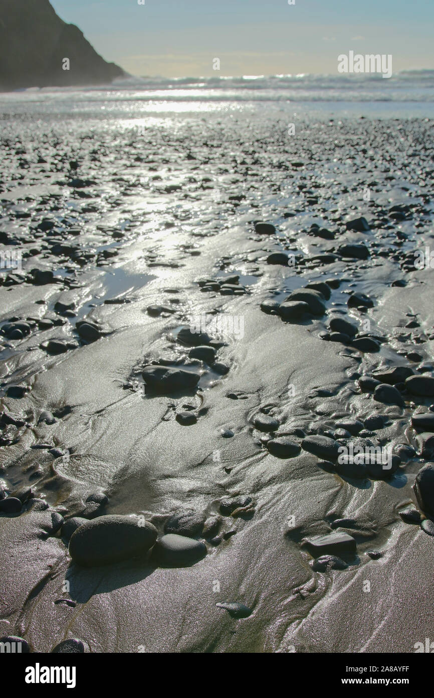 Les rochers et l'eau sur une plage le long de la côte de l'Oregon. Falaise et l'océan en arrière-plan. La lumière du soleil brillant dans ce magique du nord-ouest du Pacifique. Banque D'Images