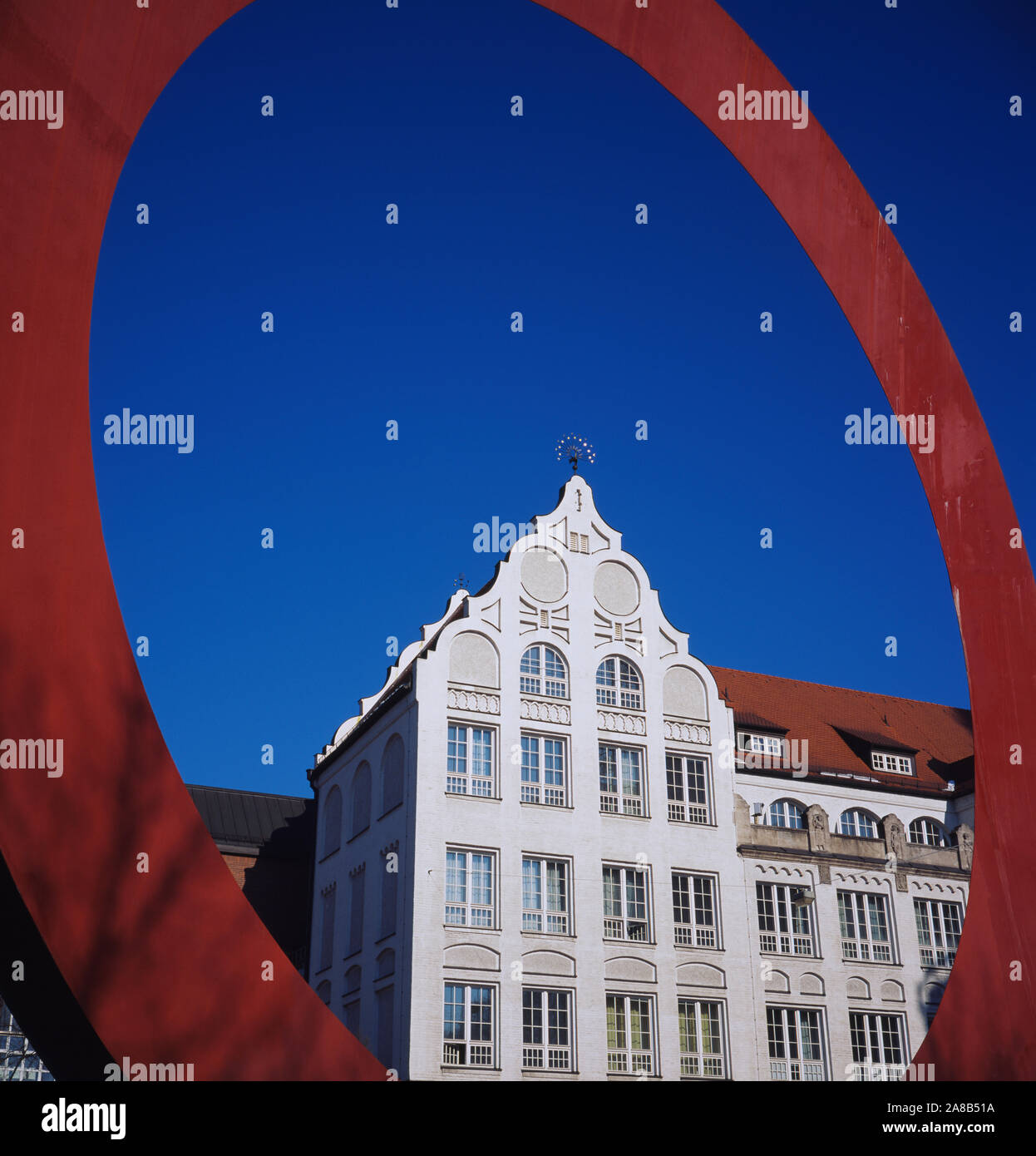 Low angle view of a building à travers une sculpture circulaire rouge, Munich, Bavière, Allemagne Banque D'Images
