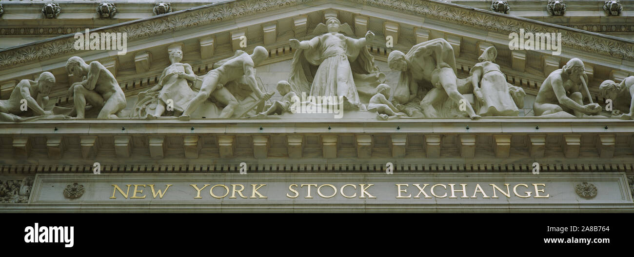Low angle view of statues sur la porte d'un immeuble financier, Bourse de New York, Wall Street, Manhattan, New York City, New York State, USA Banque D'Images