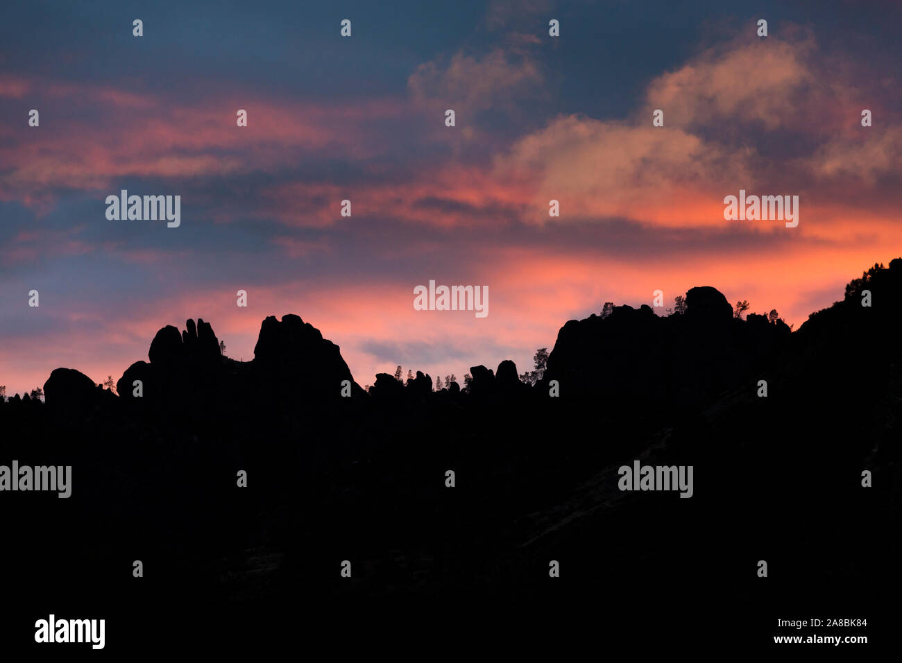 Les hauts sommets dans le Parc National de pinacles silhouetté par un coucher de soleil (Californie). Banque D'Images