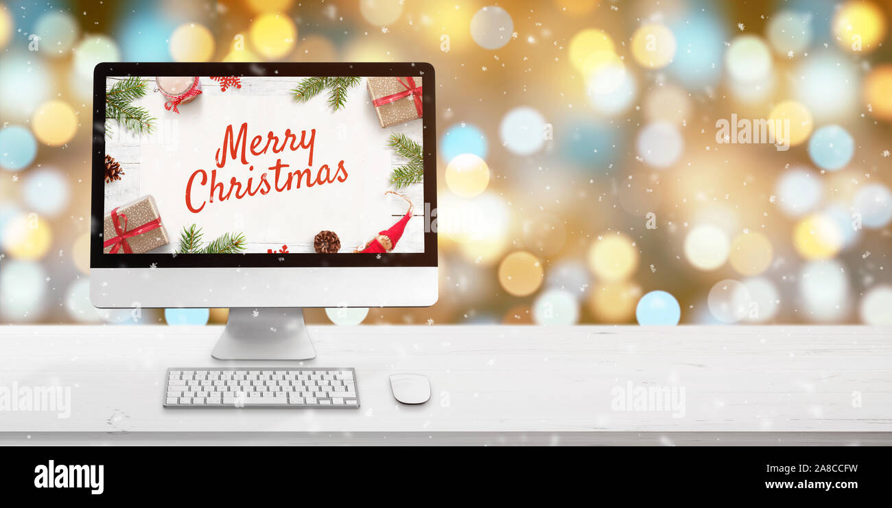 Joyeux Noël à l'écran de l'ordinateur sur le bureau en bois blanc. Les  lumières de Noël et de flou en arrière-plan. Copie espace à côté. Clavier  et souris sur Photo Stock -