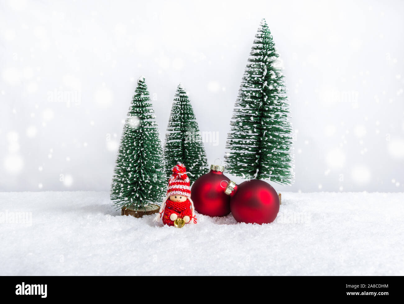 Poupée de Noël en tant que petit enfant tricoté en pull rouge holding bell près de boules de Noël et des sapins. Les chiffres de Noël fait main comme maison de vacances decorati Banque D'Images