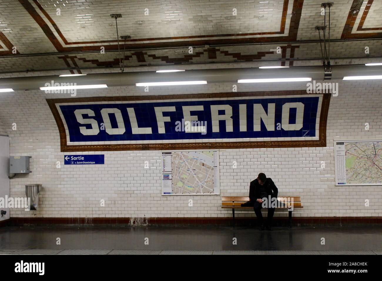 Intérieur de la station de métro Solférino paris france avec solo suis assis sur banc en bois Banque D'Images