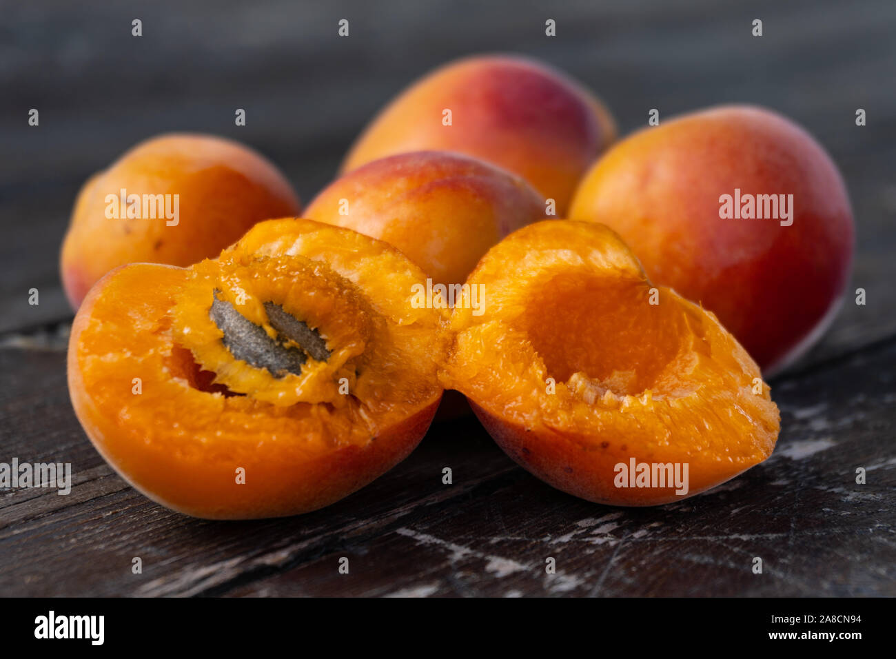 Close up d'abricots frais sur une vieille table en bois noir Banque D'Images
