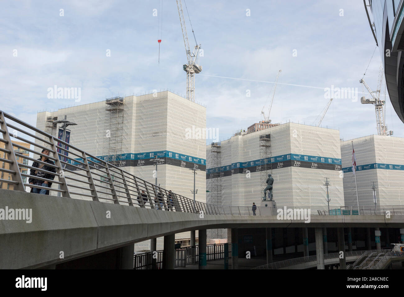 Un paysage de la régénération dans le stade de Wembley Arena où de nouvelles propriétés sont en construction sur la tour la statue du football anglais player la plus aimée, Bobby Moore, le 6 novembre 2019, à Wembley, Londres, Angleterre. Sir Bobby Moore, capitaine de l'Angleterre pour sa victoire en Coupe du Monde contre l'Allemagne à l'ancien stade de Wembley en 1966. Banque D'Images