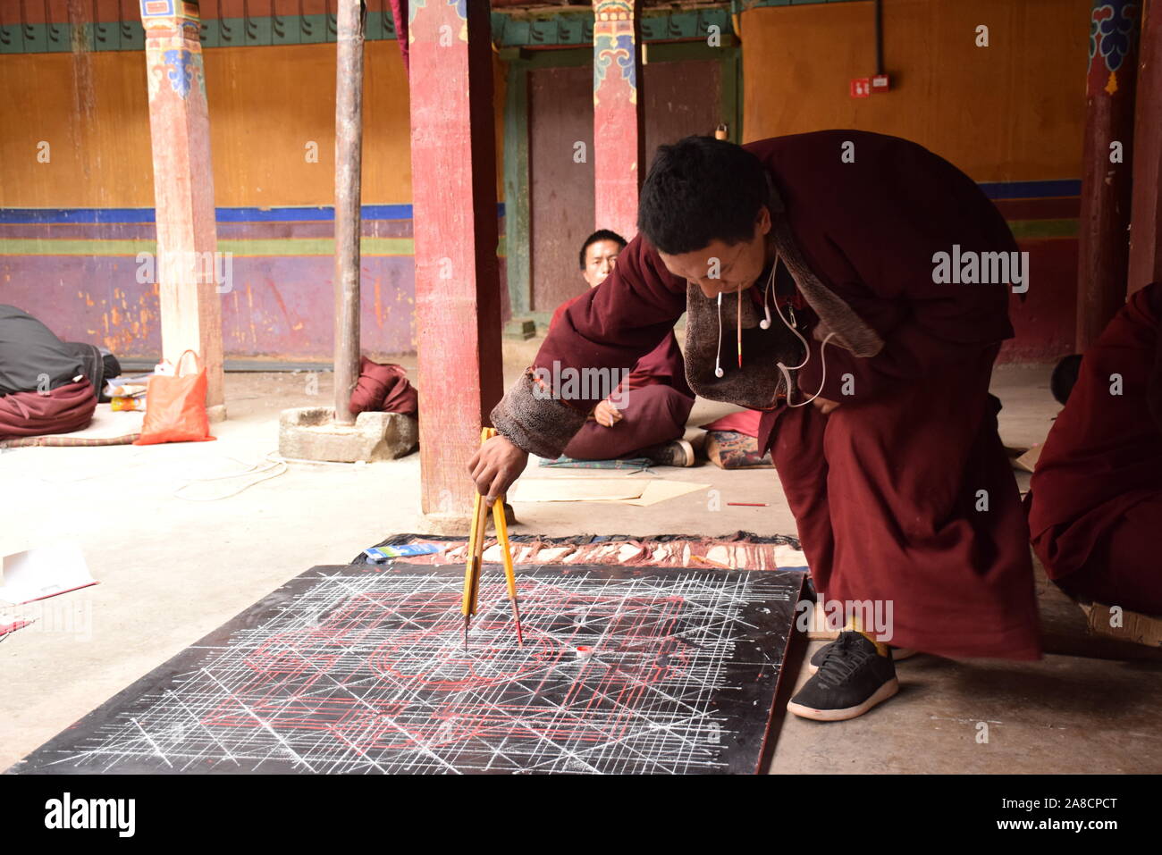 Le moine bouddhiste pratiquant dessinant un mandala à l'intérieur du monastère de Sakya, comté de Tingri, Tibet - Chine Banque D'Images