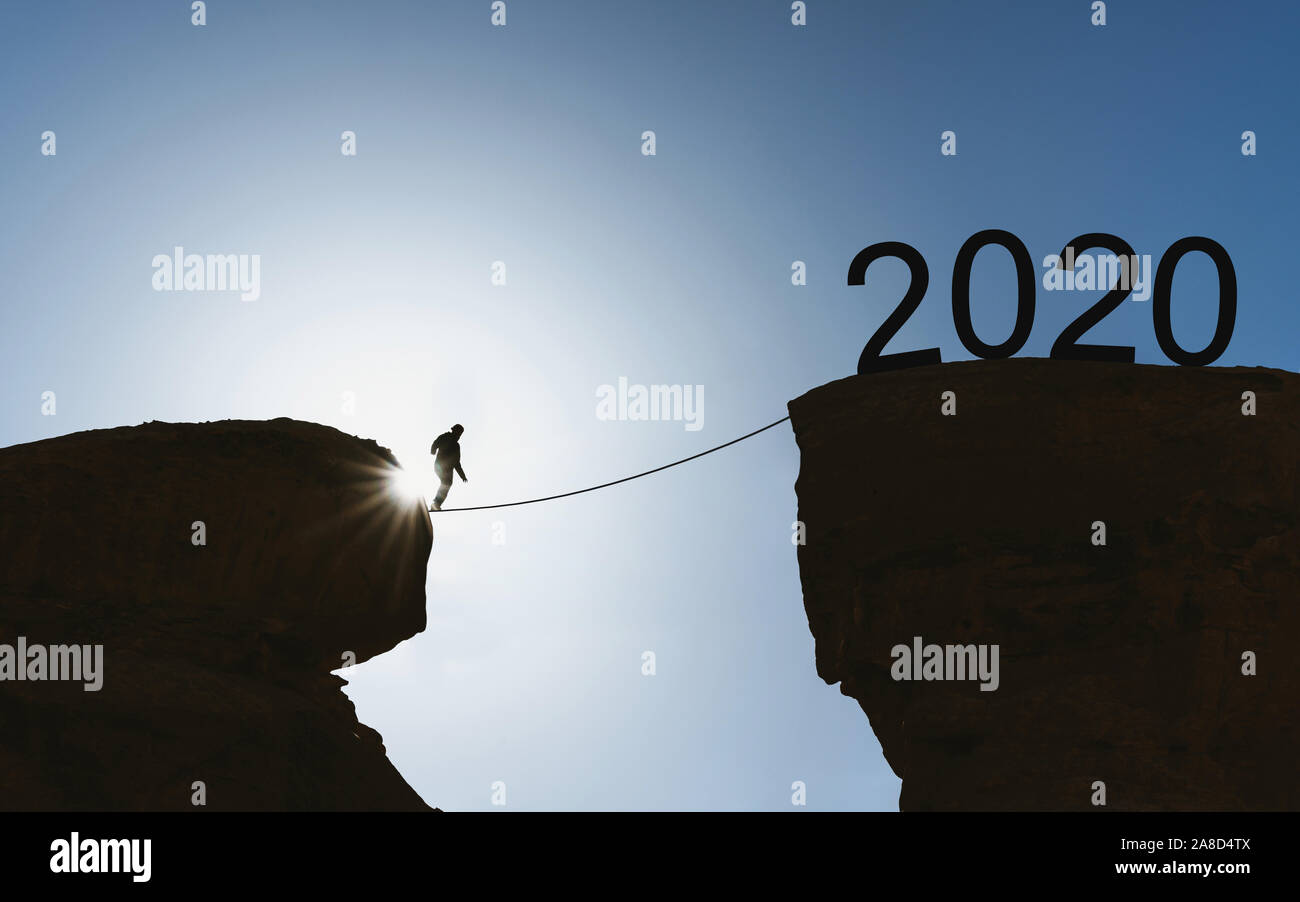 Silhouette un homme marche sur corde falaise de passage à l'an 2020, la nouvelle année 2020 et les concepts de défi Banque D'Images