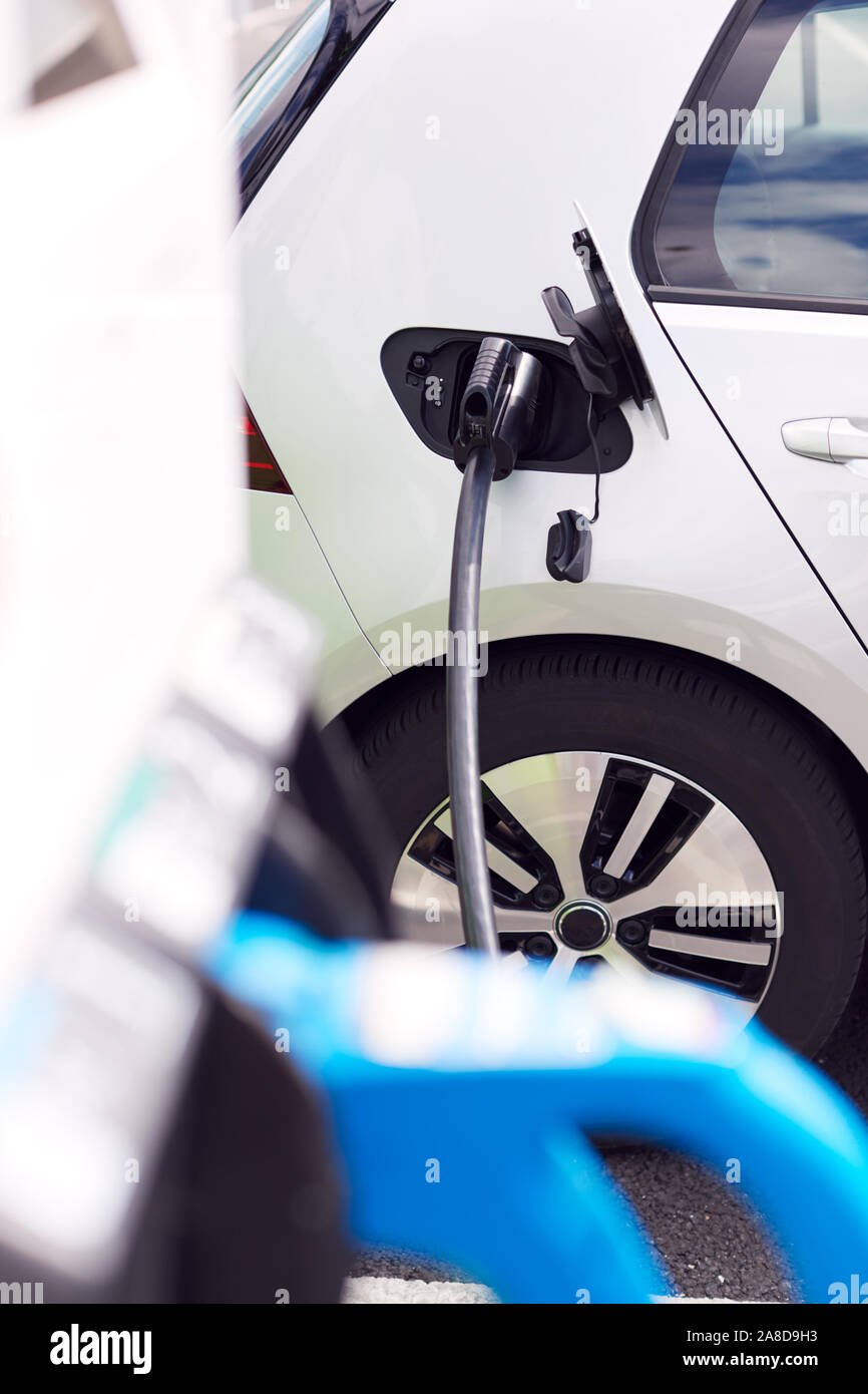 Câble d'alimentation de voiture électrique de charge à l'extérieur dans le parking de supermarché Banque D'Images