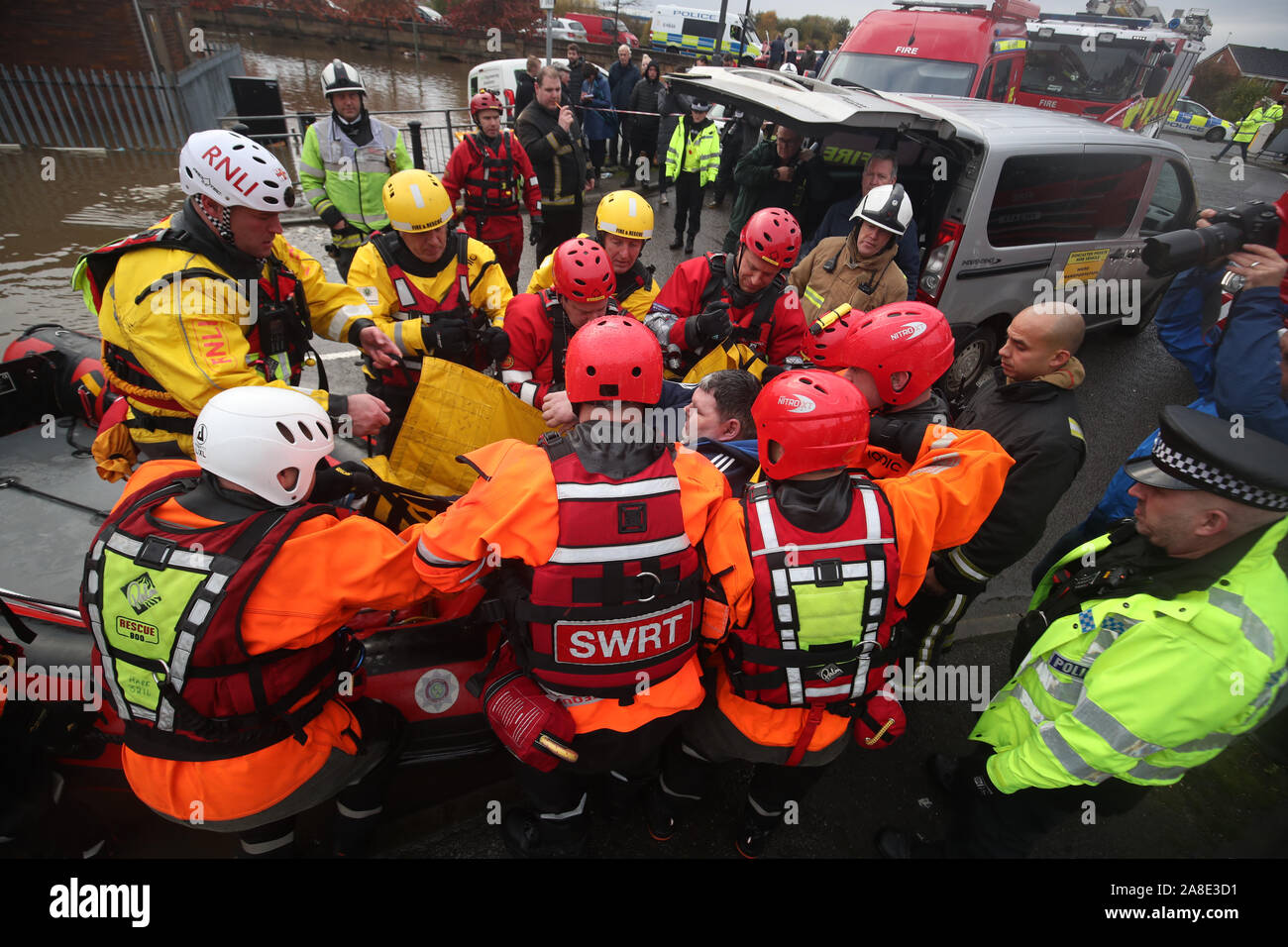 Les membres du service d'incendie et de sauvetage de lever un homme sur un bateau gonflable qui a été utilisé pour sauver les habitants piégés par l'inondation dans la région de Doncaster, dans le Yorkshire, comme certaines parties de l'Angleterre a connu un mois de pluie en 24 heures, avec des dizaines de personnes secourues ou forcés d'évacuer leurs maisons, d'autres coincés la nuit dans un centre commercial et des plans de voyage jeté dans le chaos. Banque D'Images