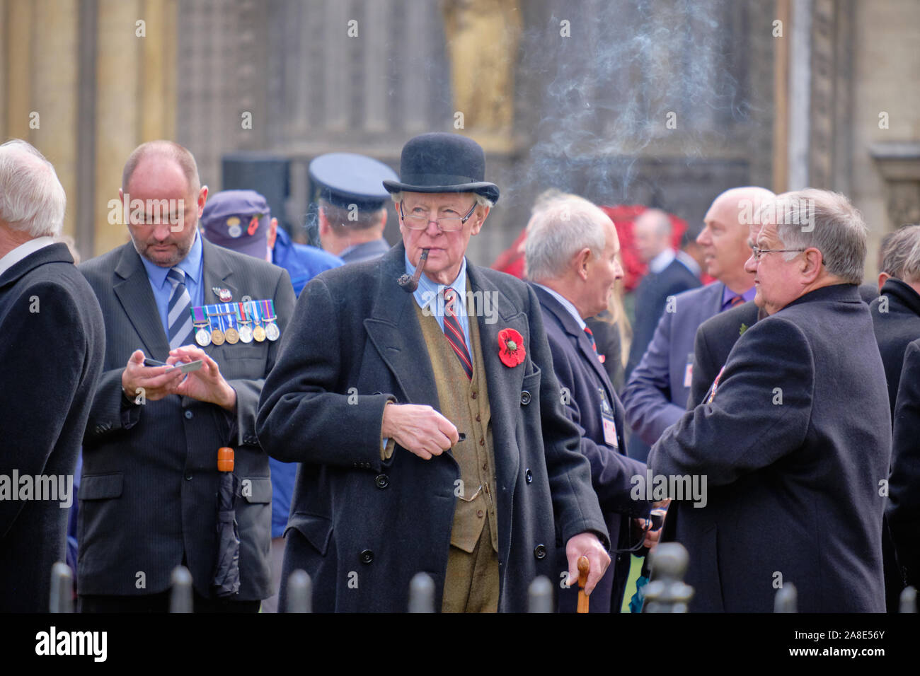 Monsieur distingué avec un costume et un chapeau melon fumant une pipe pour  assister à une cérémonie du souvenir à Londres Photo Stock - Alamy