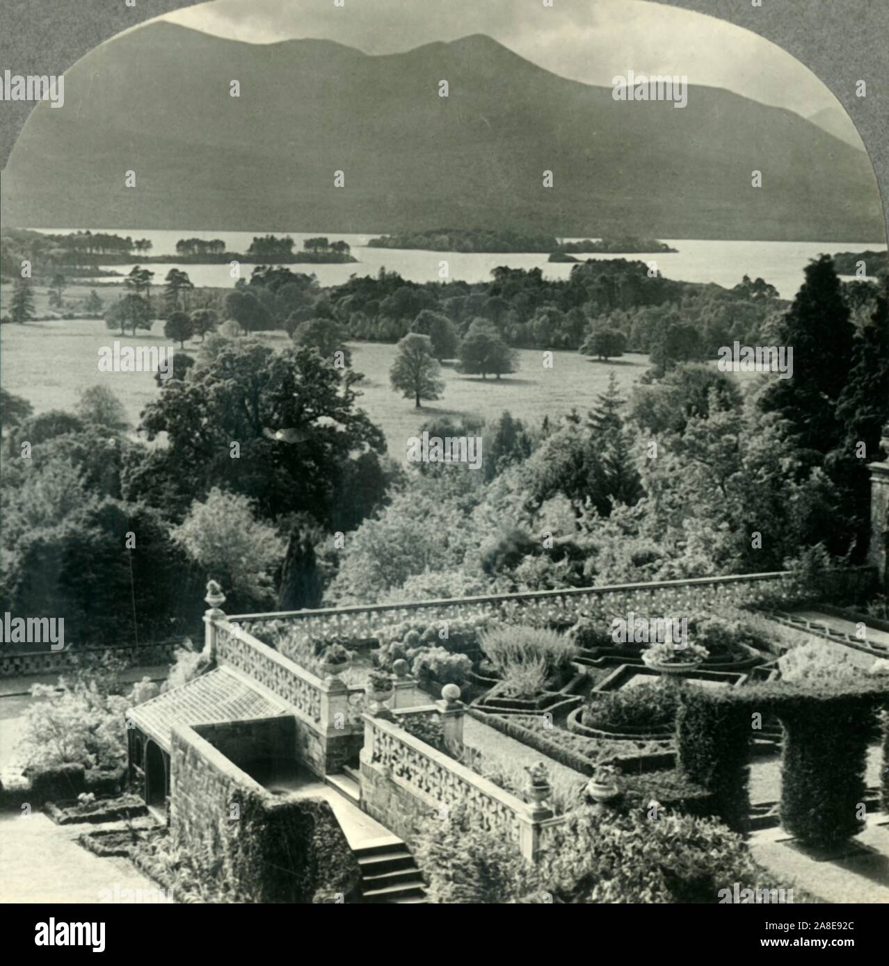 'Inférieur du lac Killarney, au sud-ouest de la demeure de Lord Kenmare, comté de Kerry, Irlande", c1930s. Vue depuis la terrasse de Kenmare House sur les rives du lac Lough Leane, les lacs de Killarney. À partir de la "Tour du monde". [Keystone View Company, Meadville, Pennsylvanie, New York, Chicago, Londres] Banque D'Images