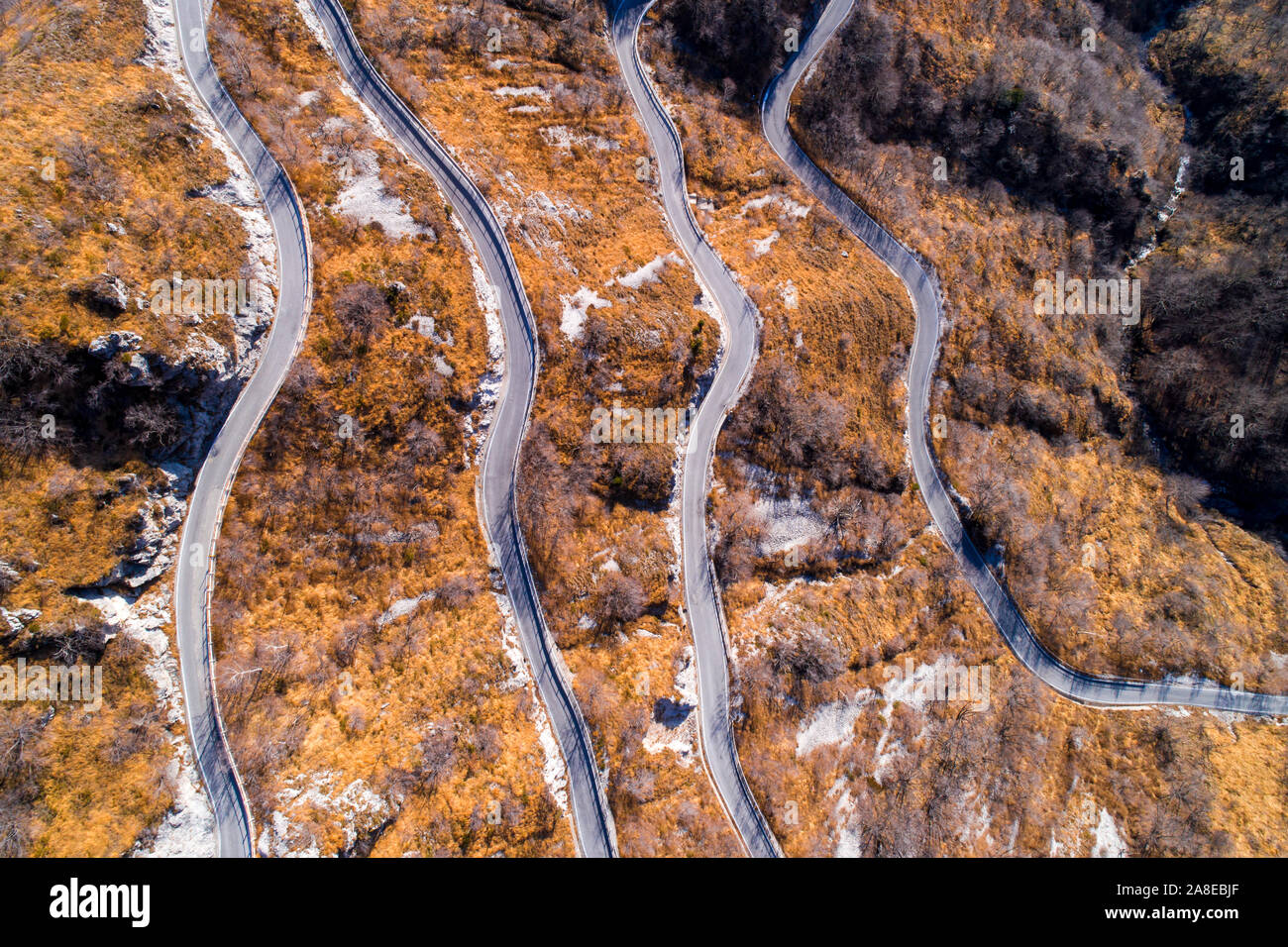 Vue aérienne de la route sinueuse de montagne en automne ou en hiver. Paysage avec les prés jaunes d'herbe sèche et étroite route asphaltée. Vue d'en haut. Banque D'Images
