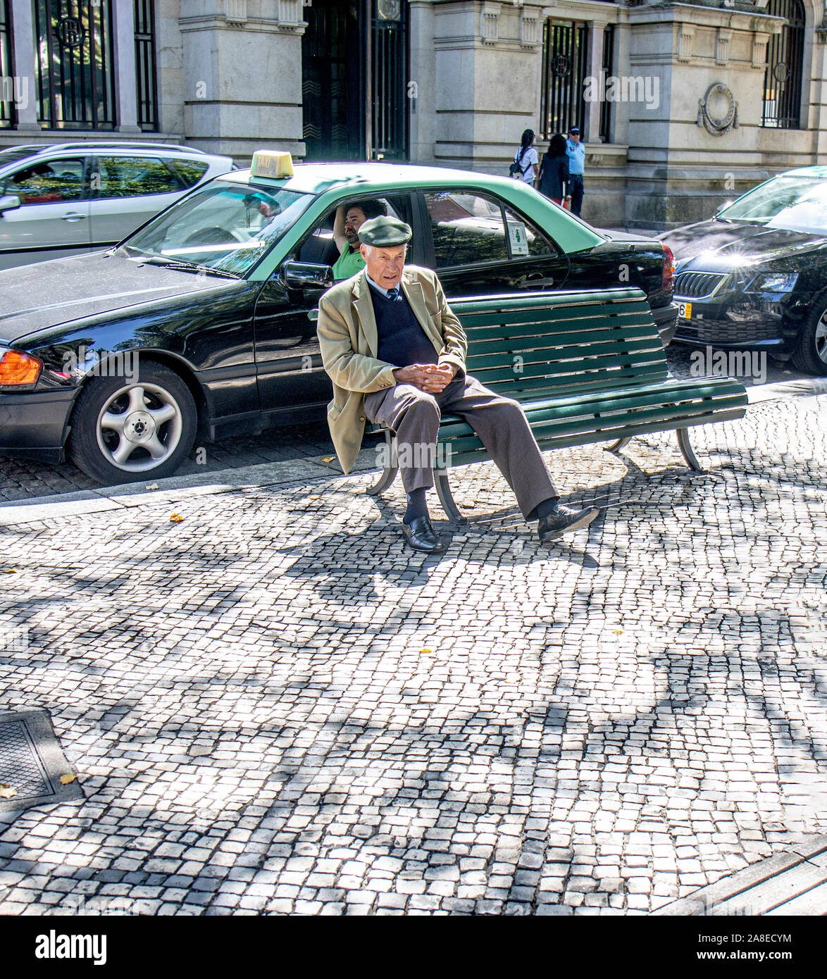 Pensionné assis sur un banc à l'ombre à Viseu, Portugal Banque D'Images