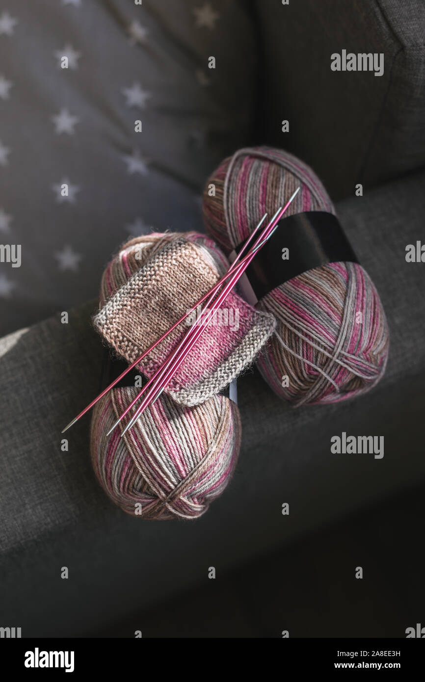 Des échevettes de fils de laine et aiguilles à tricoter à la main des chaussettes. Couleurs naturelles. Concept pour fait main. Banque D'Images