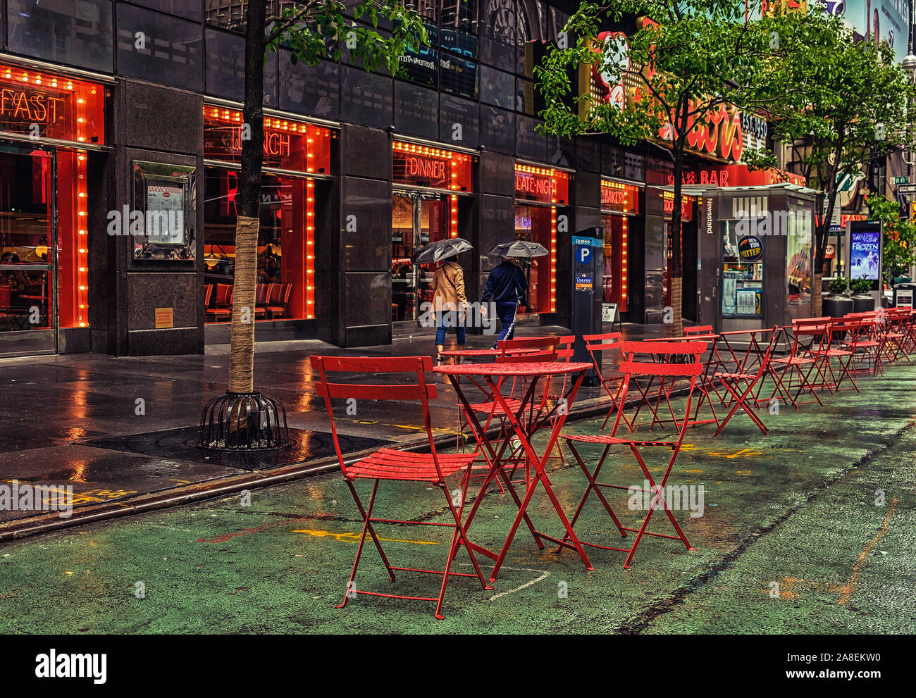 New York City, Etats-Unis, mai 2019, vue sur la façade du restaurant Junior et une terrasse avec tables et chaises rouges sur Broadway par temps de pluie Banque D'Images