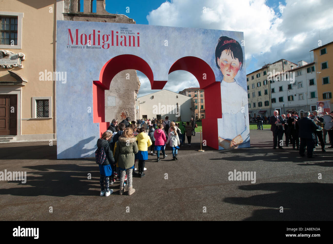 Au cours de l'ouverture, une classe d'école franchit la porte de l'exposition bienvenue 'Modigliani et l' aventure Montparnasse sur la Piazza del Luogo Pio, Liv Banque D'Images