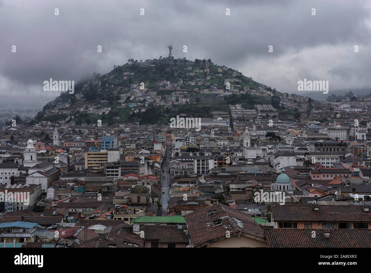 Vue sur Quito avec les routes et les édifices et la vierge d'El Panecillo sur un ciel nuageux pluvieux Banque D'Images