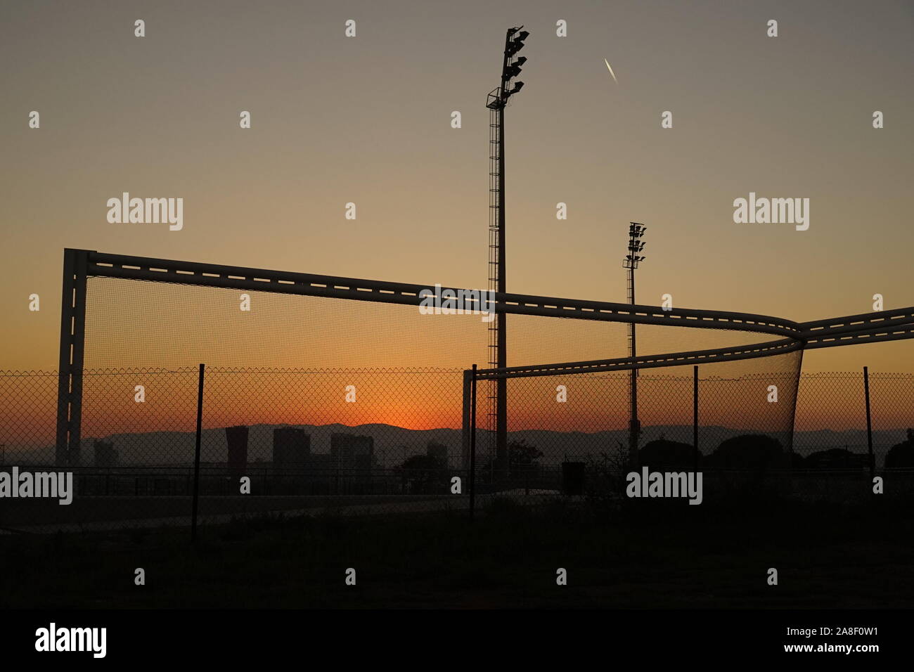 Le bord de la ville de Barcelone sports park avec des silhouettes au coucher du soleil Banque D'Images