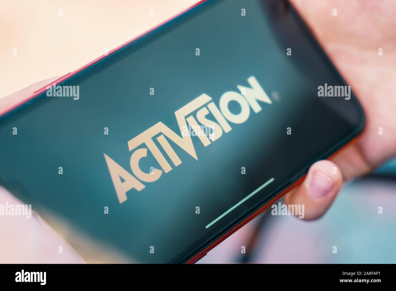 Bichkek, Kirghizistan - Octobre 4, 2019 : Man holding smartphone avec logo d'Activision à l'écran. Banque D'Images