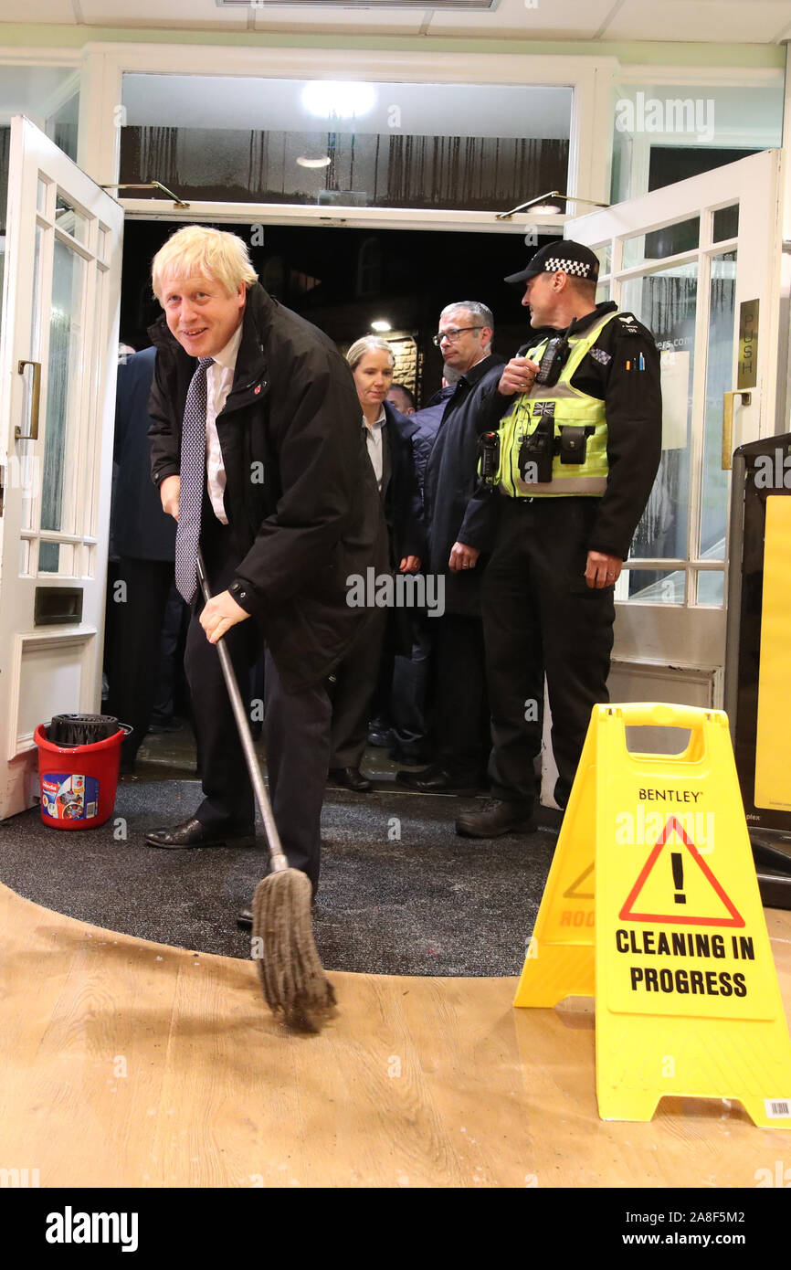 Premier ministre Boris Johnson aide à nettoyer à un opticien comme il rend visite à Matlock, Derbyshire pour voir l'inondation. Banque D'Images