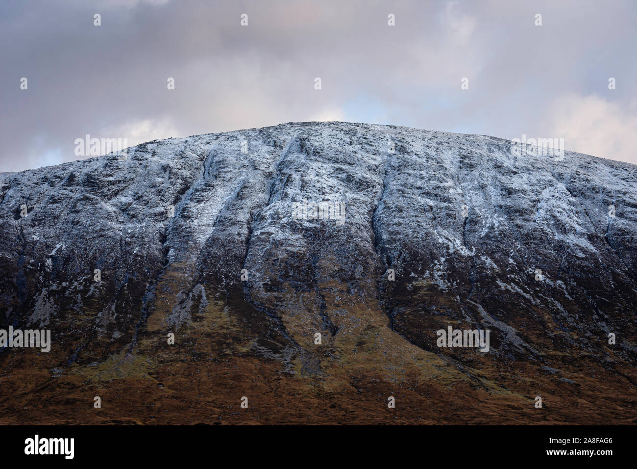 La crête de montagnes couvertes de neige dans la région de Highlands écossais pendant le changement de saison de l'automne à l'hiver.Première neige et couleurs d'automne dans la vallée.paysage majestueux. Banque D'Images