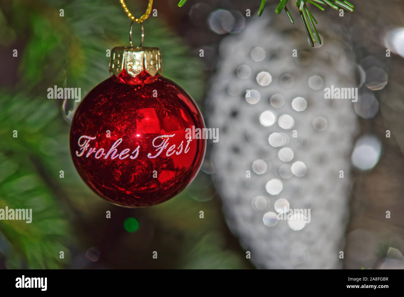 Boule de Noël rouge avec Happy Holiday texte en allemand contre blurred Christmas decoration Banque D'Images