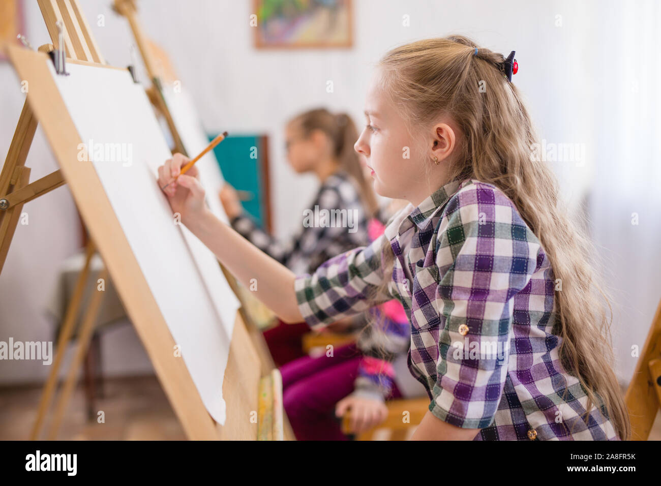Enfants de dessiner sur un chevalet dans l'école d'art Photo Stock - Alamy
