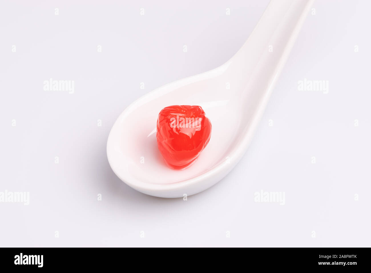 Cerise au marasquin dans un bol blanc, isolé sur fond blanc, une lumière douce, studio shot Banque D'Images